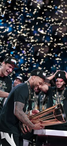 the lakers players are holding their trophy in front of confetti