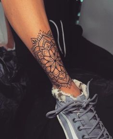 a woman's foot with a tattoo on it and a lace - up sneaker