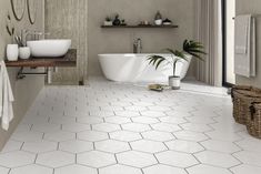 a bathroom with white hexagonal tile floors and walls, along with a large bathtub