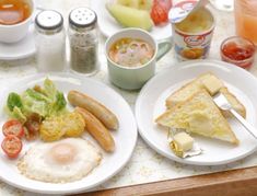 two white plates topped with food next to cups and saucers