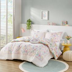 a bed with white sheets and pillows in a bedroom next to a rug on the floor