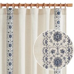 a curtain with blue flowers on it and a wooden rod in front of the curtain