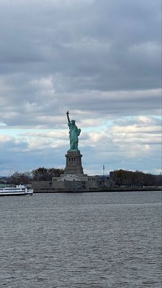 the statue of liberty stands in front of a body of water with boats on it