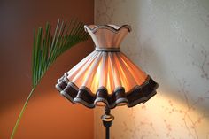 a lamp that is on top of a table next to a potted palm tree