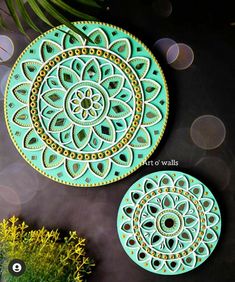 two decorative plates sitting next to each other on top of a black surface with yellow flowers in the background