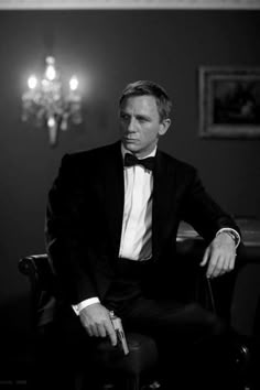 a man in a tuxedo sitting on a chair