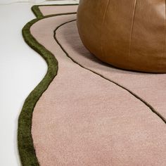 a large brown leather ball sitting on top of a rug next to a white floor