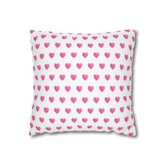 a white pillow with pink hearts on it