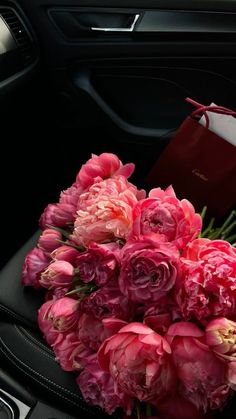 a bouquet of pink flowers sitting on top of a car seat