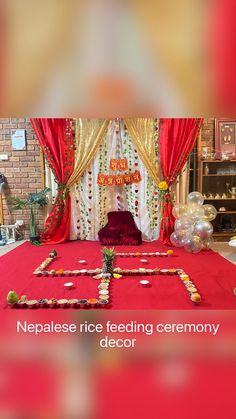 a red carpeted room with decorations and balloons on the floor that read nepalese rice feeding ceremony decor