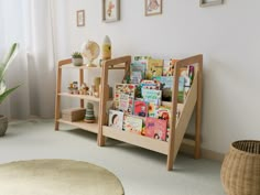 a child's bookshelf in the corner of a room with pictures on the wall