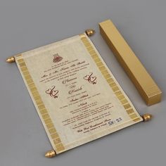 a wedding card and its box on a grey surface with gold trimmings, next to it's matching ribbon