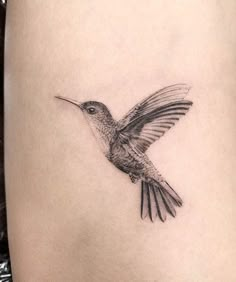 a small hummingbird tattoo on the thigh