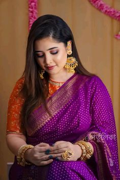 a woman in a purple and orange sari