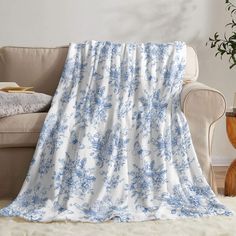 a blue and white floral print blanket on a couch