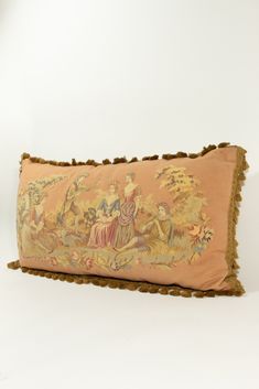 an embroidered pillow with tassels on the bottom and fringe trim around the edges