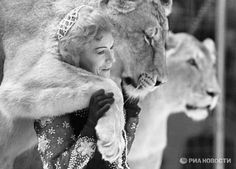 a woman is hugging a lion in front of her