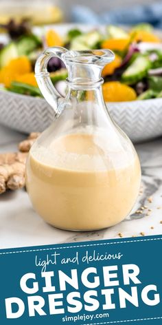 a glass bottle filled with dressing next to a bowl of salad and an orange slice