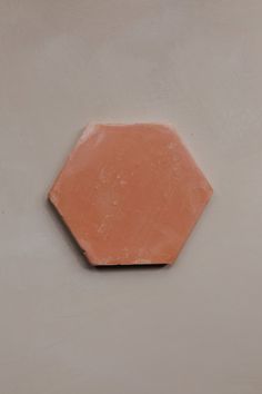 an orange hexagonal object on a white wall