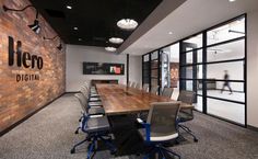 an empty conference room with wooden tables and chairs in front of a brick wall that reads elero digital