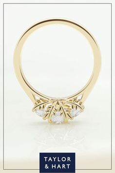 a yellow gold ring with three stones on it