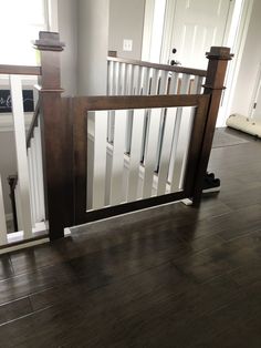 an empty room with wood flooring and white railings on the second story stairs