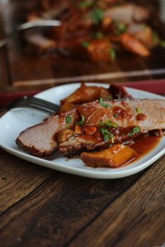 a white plate topped with meat covered in sauce