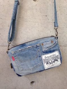 an old pair of jeans is hanging from a purse on the ground with a chain