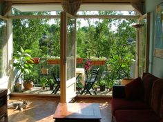 an open living room with sliding glass doors leading to the outside patio and trees in the background