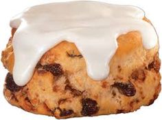 a pastry with icing and raisins on it