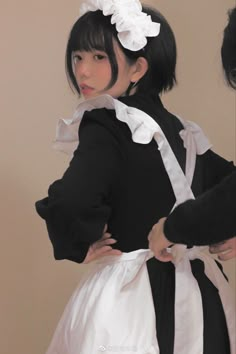 a woman wearing a black and white dress with flowers in her hair