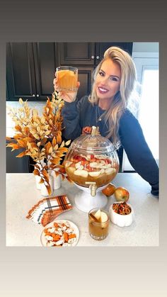 a woman sitting at a table with food and drinks