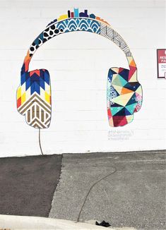 a white wall with colorful headphones painted on it