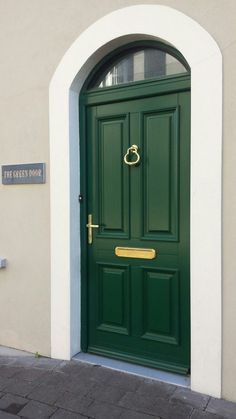 a green front door on a white building