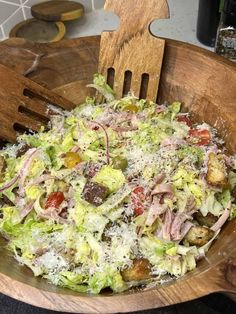 a wooden bowl filled with lots of salad