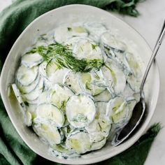 a white bowl filled with cucumbers and cream