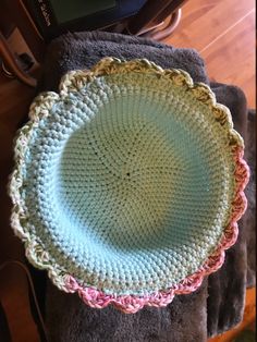 a crocheted dish sits on top of a blanket