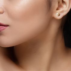 a close up shot of a woman's face with earrings on her ear and nose