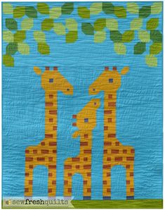 two giraffes standing next to each other on a quilted wall hanging