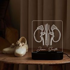 a pair of white shoes sitting on top of a table next to a glass plaque