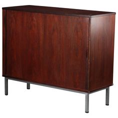 a large wooden cabinet with metal legs