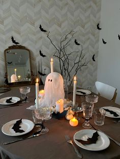 a dining room table decorated for halloween with candles and decorations