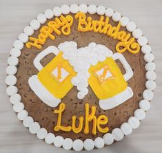 a birthday cake decorated with beer mugs and the words happy birthday luke on it