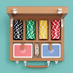 an open suitcase with four different colored cards in it and two dice holders on the inside