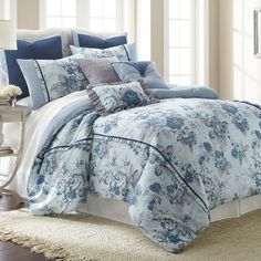 a bed with blue and white comforters in a room