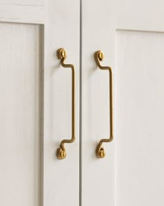 an image of a door handle that is on the side of a white door with gold handles