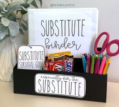 a desk with some pens, pencils, markers and a sign that says substitue binder