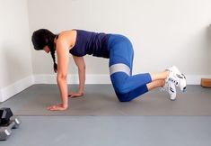 a woman is doing push ups on the floor