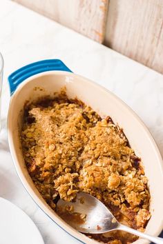 a casserole dish with crumbled toppings and a glass of water