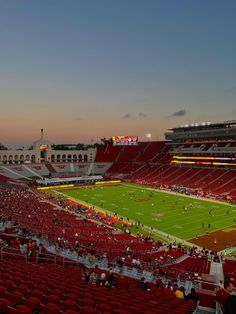 an empty stadium filled with people watching a football game at sunset or dawn in the evening